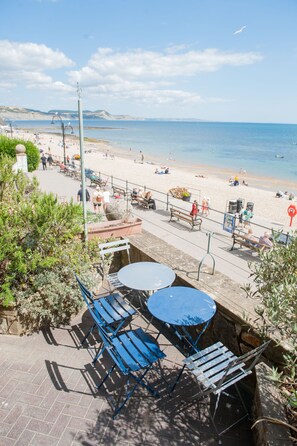 Une terrasse en bord de mer avec des sièges extérieurs et une vue sur la plage.