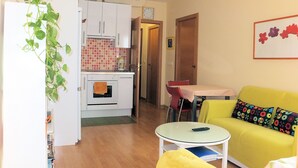A compact living space with a kitchenette, a dining area, and a sofa. - Cute and quiet, in the city center, paid parking (Sevilla)