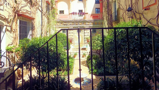 A courtyard with a tiled floor, a fountain, and a building with arches and a balcony. - Cute and quiet, in the city center, paid parking (Sevilla)