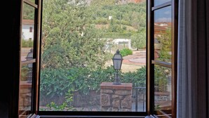 A room with a large window overlooking a mountainous landscape.