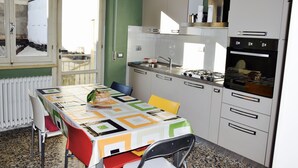 Cuina amb taula per a dues persones, fogó i armaris.