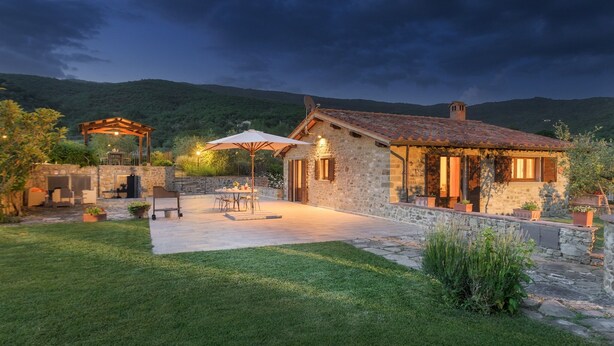 A stone house with a tiled roof, a patio with outdoor furniture, and a garden. - Vinciluna 4, Emma Villas (Scanizza)