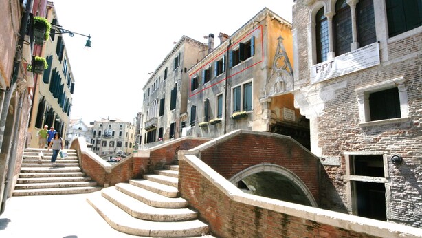 Una caratteristica via veneziana con una scalinata che conduce a un canale.