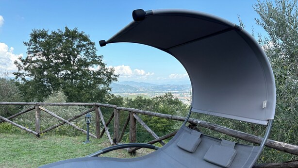 A reclining chair with a canopy, set against a scenic backdrop of trees and distant mountains. - detached villa with a private swimming pool and a large terrain (Umbertide)