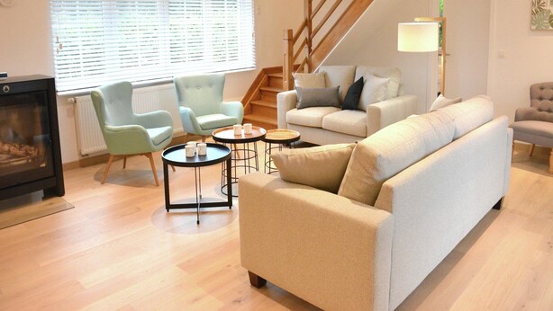 Un salon comprenant un canapé, des fauteuils, une table basse et une cheminée.