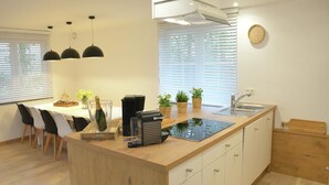 Une cuisine moderne dotée d’un îlot central, d’un évier intégré et d’un coin repas avec des chaises.