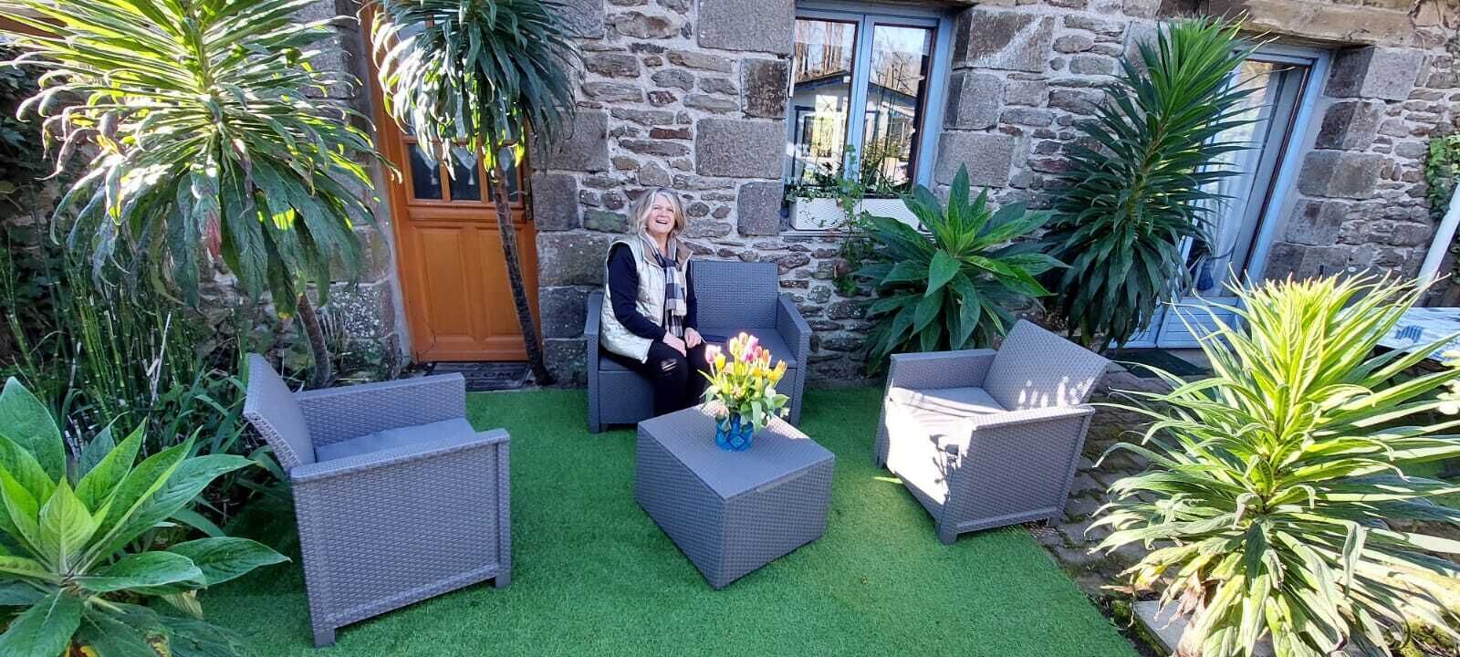 Une terrasse avec des meubles en osier et une plante en pot.