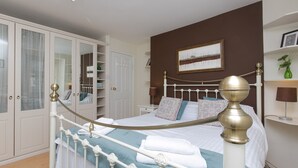 A neatly arranged bedroom with a bed, bedside tables, a wardrobe, and a painting on the wall. - Awelon sleeps 10, Hot Tub, Log Burner, private courtyard, Porthmadog, Snowdonia (porthmadog)