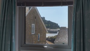 Una ventana con vista a un edificio de piedra y un puente.