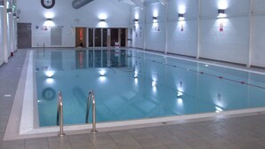 An indoor swimming pool with clear lanes, a clock on the wall, and a no-smoking sign. - Filey. Active leisure or relaxing beach holiday. (Filey)