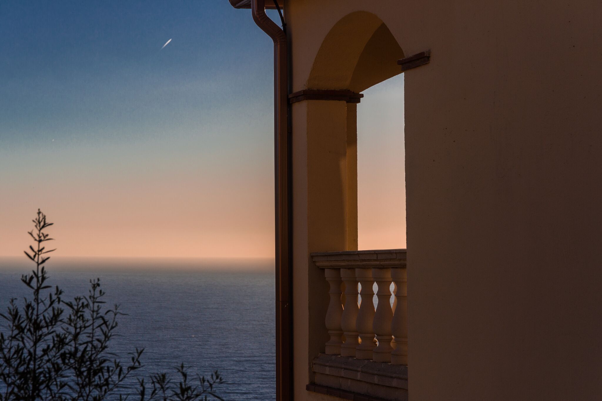 Un balcon avec vue sur la mer et un ciel dégagé.