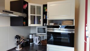 Eine moderne Küche mit Einbauofen, Mikrowelle und Kaffeemaschine.