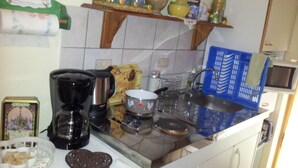 A kitchen with a coffee maker, kettle, and various kitchen utensils on the counter. - Comme chez vous prés sur la route des vins! (Mutzig)