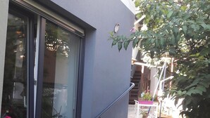 A building exterior with a window, a metal handrail, and potted plants. - Comme chez vous prés sur la route des vins! (Mutzig)
