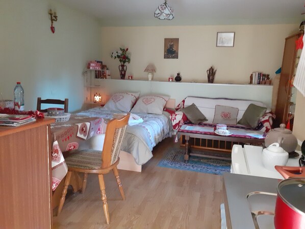 Une chambre confortable avec un lit, une table de chevet, une chaise et un bureau avec une lampe.
