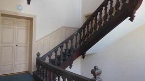 A wooden staircase with a handrail and a door at the bottom.