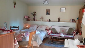 A cozy bedroom with a bed, bedside table, chair, and a desk with a lamp. - Studio proche de Strasbourg  (Mutzig)