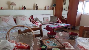 A cozy living room with a sofa, a coffee table, and a dining table. There are decorative items and a basket on the floor. - Studio proche de Strasbourg  (Mutzig)