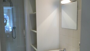 A bathroom with a shower, a sink, and a toilet. - Historic center - Old market (Rouen)