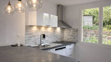 Una cucina moderna con un'ampia isola, elettrodomestici in acciaio inossidabile e una finestra vista sul verde.