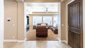 A spacious living room with a brown sectional sofa, a ceiling fan, and a large wooden door. - Zion's Point-Pet Friendly! (Washington)