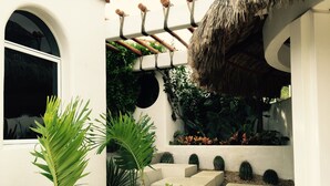 A concrete staircase leading up to a covered area with plants and a thatched roof. - BEAUTIFUL VILLA WITH PRIVATE POOL (Cabo San Lucas)