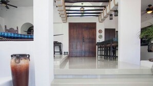 A modern interior with a wooden door, a staircase, and a dining area. - BEAUTIFUL VILLA WITH PRIVATE POOL (Cabo San Lucas)