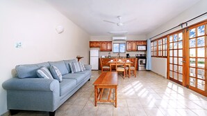 A modern kitchen with wooden cabinets, a dining table, and a built-in oven. - Beach House Condos: Beachfront Penthouse - 7mile Beach Jamaica (Negril)