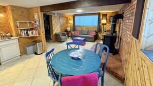 Um quarto aconchegante com uma mesa redonda, cadeiras, um sofá e uma lareira.