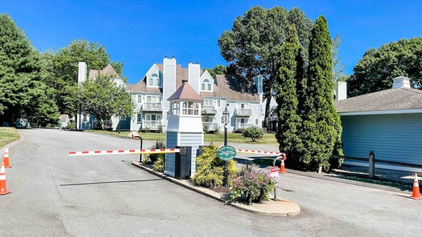 A gated entrance with a clear pathway, a security booth, and a sign indicating private property.