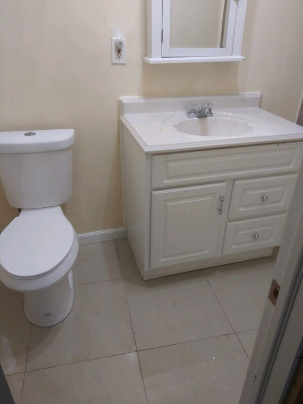 Ein Badezimmer mit Toilette, Waschbecken und einem Schrank.