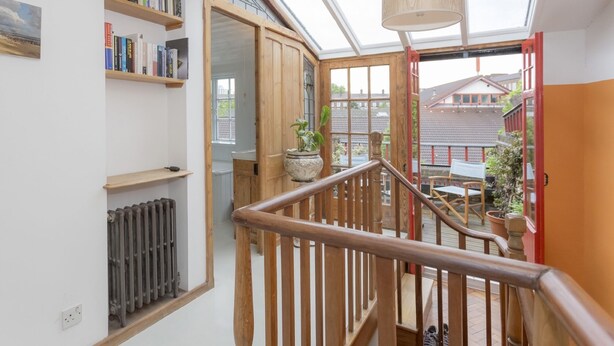 A staircase with wooden railings leading to an outdoor area with a view of a house. - Gorgeous apartment in zone 1, near the river and a short walk from Westminster   (London)