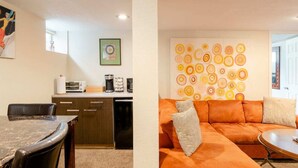 Una cocina moderna con comedor, un conjunto de sofás y una obra de arte en la pared.