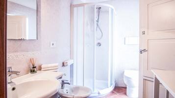 Un bagno con doccia, lavabo, bidet e WC.