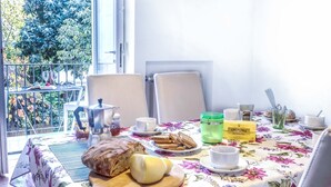 Ein Frühstückstisch mit Stühlen und Blick auf einen Balkon.