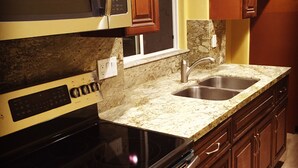 A kitchen with a microwave, stove, oven, sink, and wooden cabinets. - Temecula Wine Country Guest House w/Kitchen - Prime Location (Temecula)