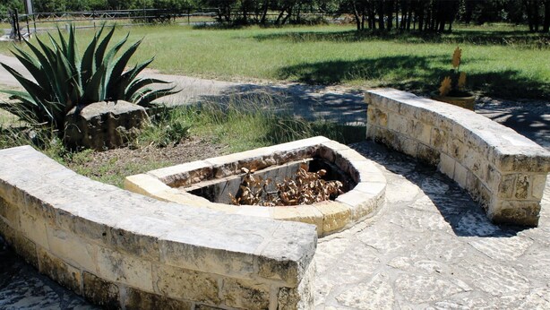 Un hogar de piedra con un diseño rústico, rodeado por un sendero de piedra y una zona cubierta de césped.