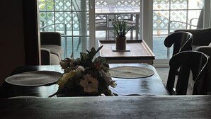 A dining area with a view of a lake through large glass doors. - Charming home with stunning lake views! (Watkins Glen)