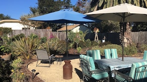 A patio with outdoor furniture, a windmill, and a wooden fence. - Dog Friendly, Allergen-free 5 minute walk to the bay and eateries (Los Osos -Baywood Park)