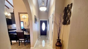 A hallway with a chandelier, a dining area, and a vase on the right. - Newly Updated! Private Beach Views, Luxury Villa Milagro Villa 1 (St.Thomas U.S.V.I)