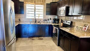 A kitchen with dark cabinets, a stainless steel refrigerator, a microwave, and a stove. - Newly Updated! Private Beach Views, Luxury Villa Milagro Villa 1 (St.Thomas U.S.V.I)