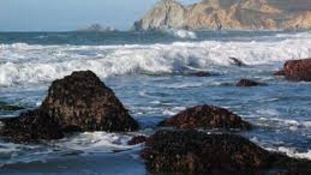 A coastal scene with rocky outcrops and waves.