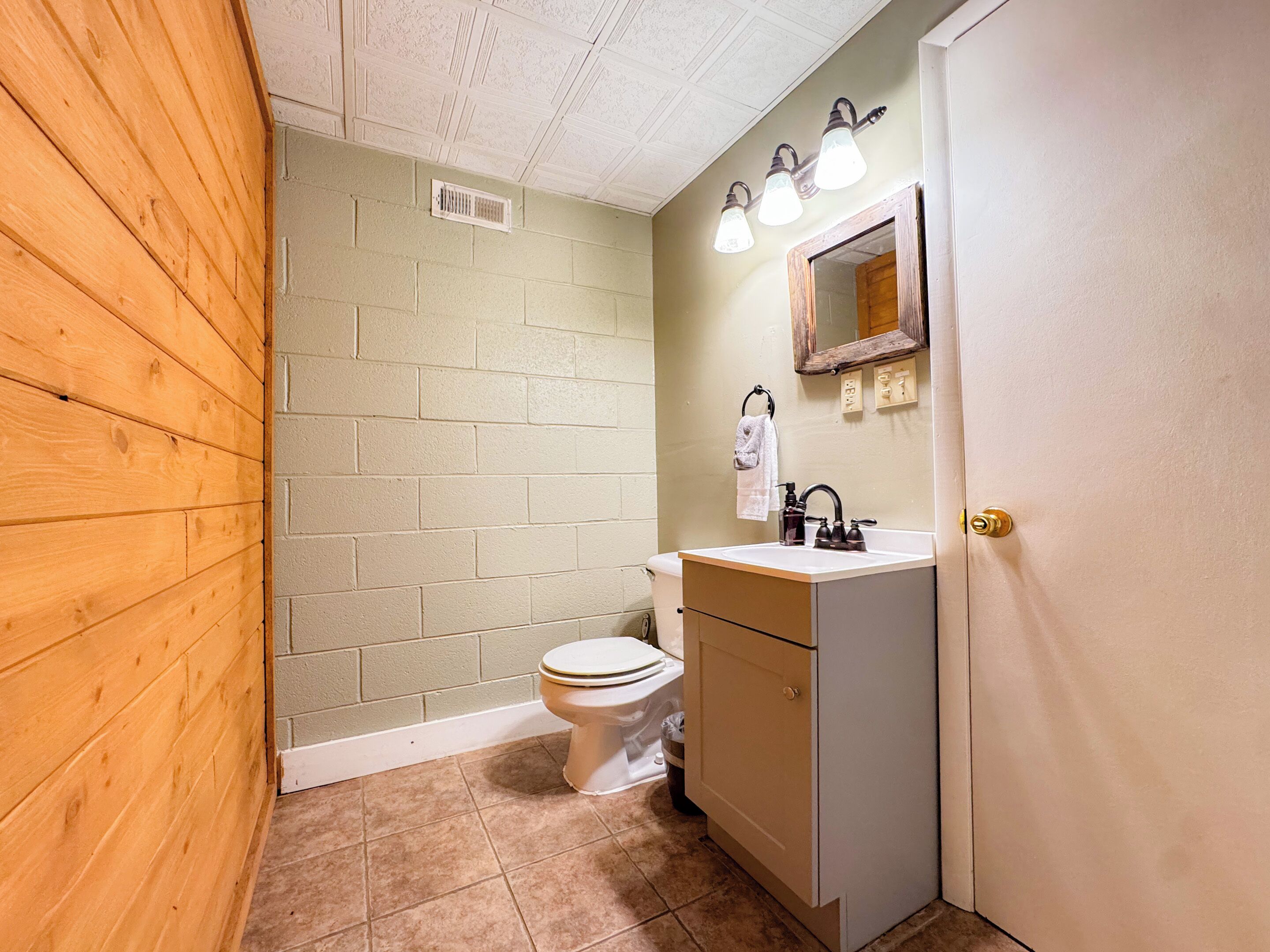 Ein Badezimmer mit Toilette, Waschbecken und Spiegel.