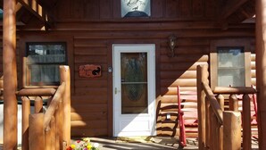 A wooden cabin with a rustic fox sign, a glass door, and a welcome mat. - Enjoy Secluded Mountain Paradise at the Rustic Fox! (Sevierville)