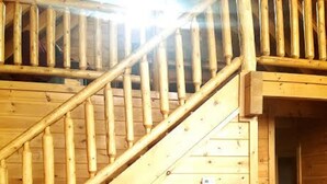 A wooden staircase with a wooden handrail and a wooden wall. - Enjoy Secluded Mountain Paradise at the Rustic Fox! (Sevierville)