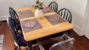 A dining table with a vase of flowers, brown placemats, and black chairs. - #2 UAB 2bd2bth in the heart of city (Birmingham)