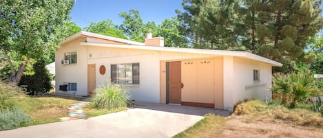 A single-story house with a garage, a small porch, and a concrete driveway.