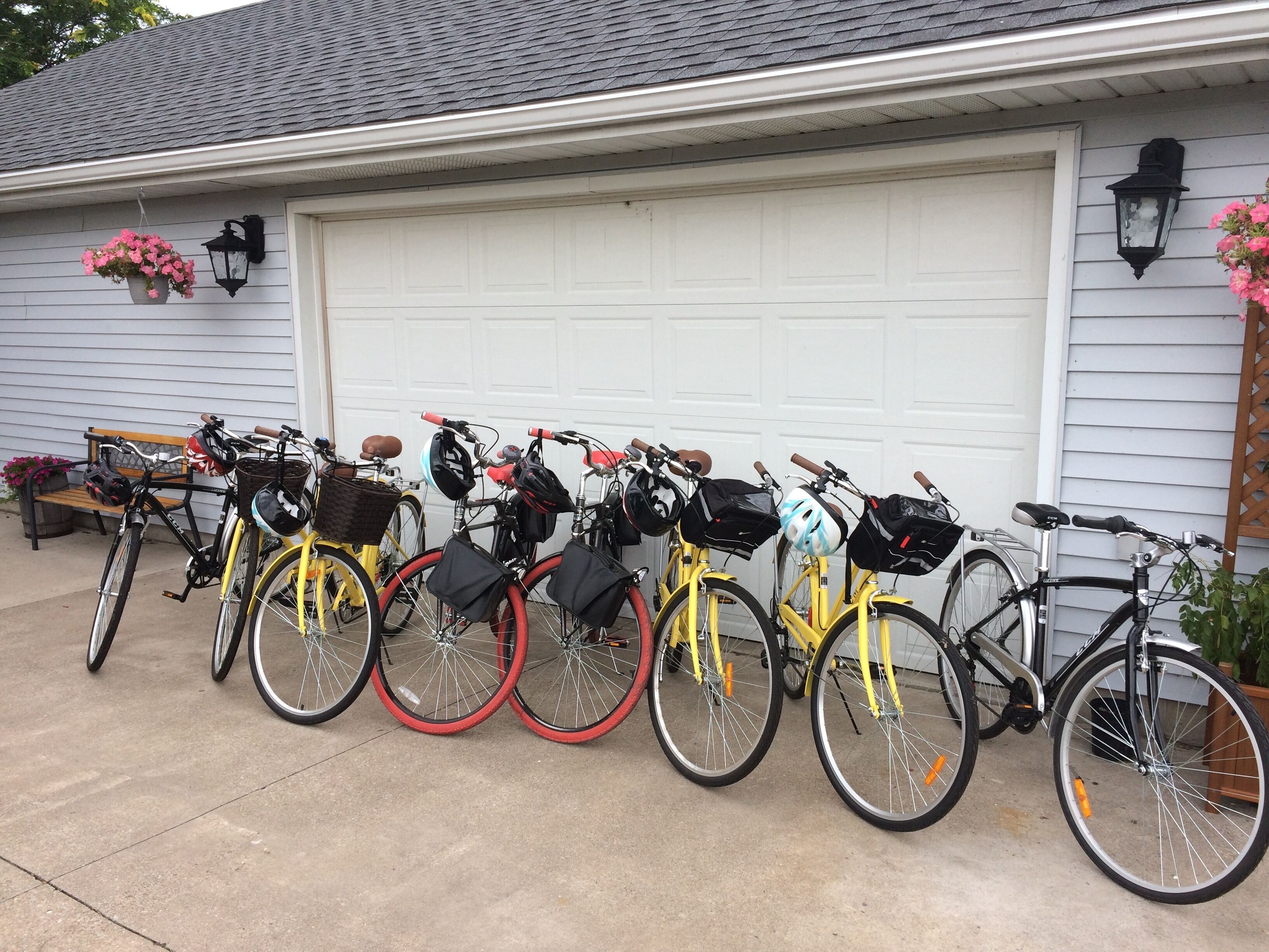 Diverse biciclette parcheggiate davanti a un garage con una porta bianca.