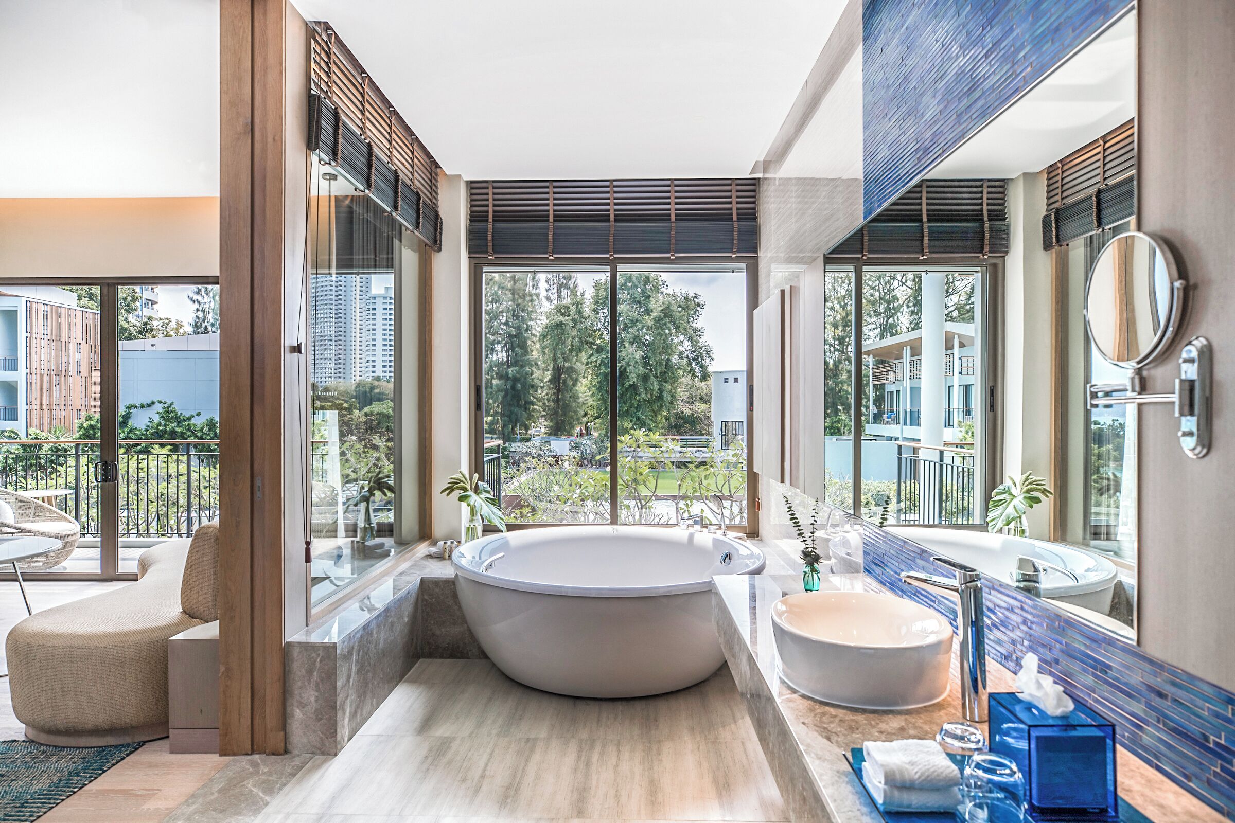 Un baño moderno con una bañera grande, un lavabo independiente y un ventanal con vistas al exterior.