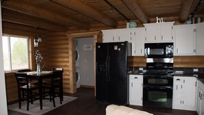 A kitchen with wooden cabinets, a refrigerator, an oven, and a microwave.